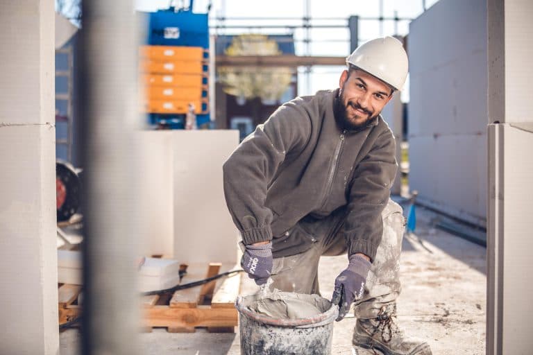 bouwvakker op een knie aan het werk